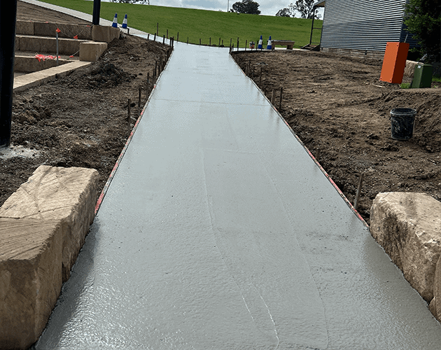 Freshly poured concrete pathway for commercial construction site.