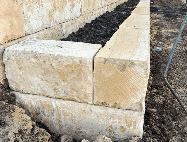 Close-up of stone wall construction with large sandstone blocks for commercial site.