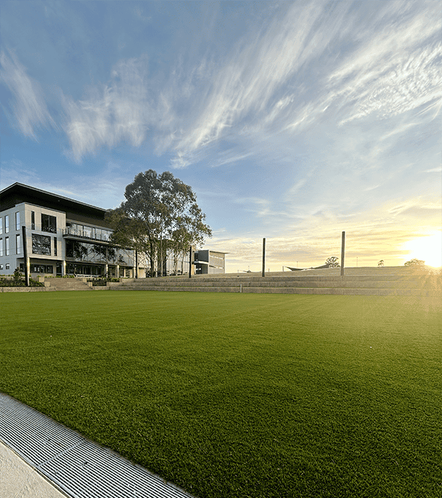 Contemporary residential building with lush green lawn and clear sky.