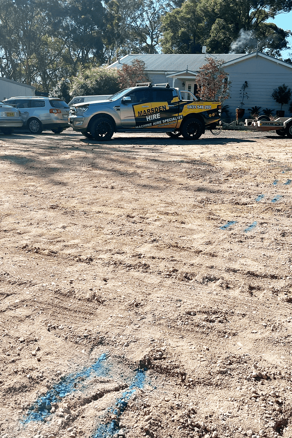 Construction site with Marpen Hire Service truck and parked cars.