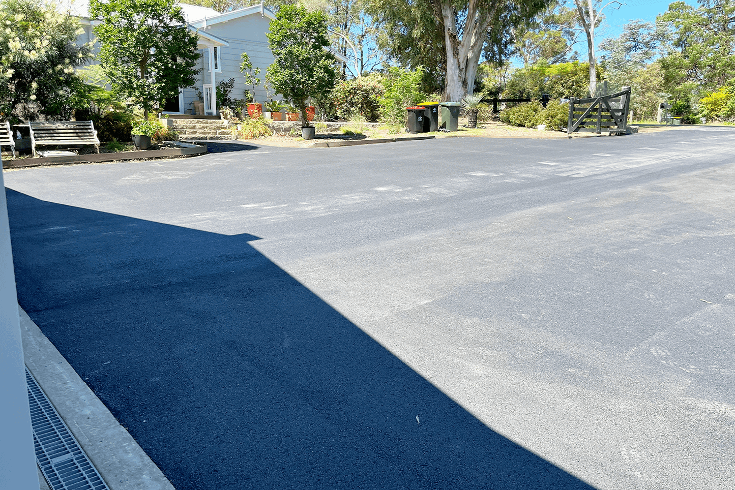 Freshly paved asphalt driveway in Glenorie with surrounding greenery and trees.