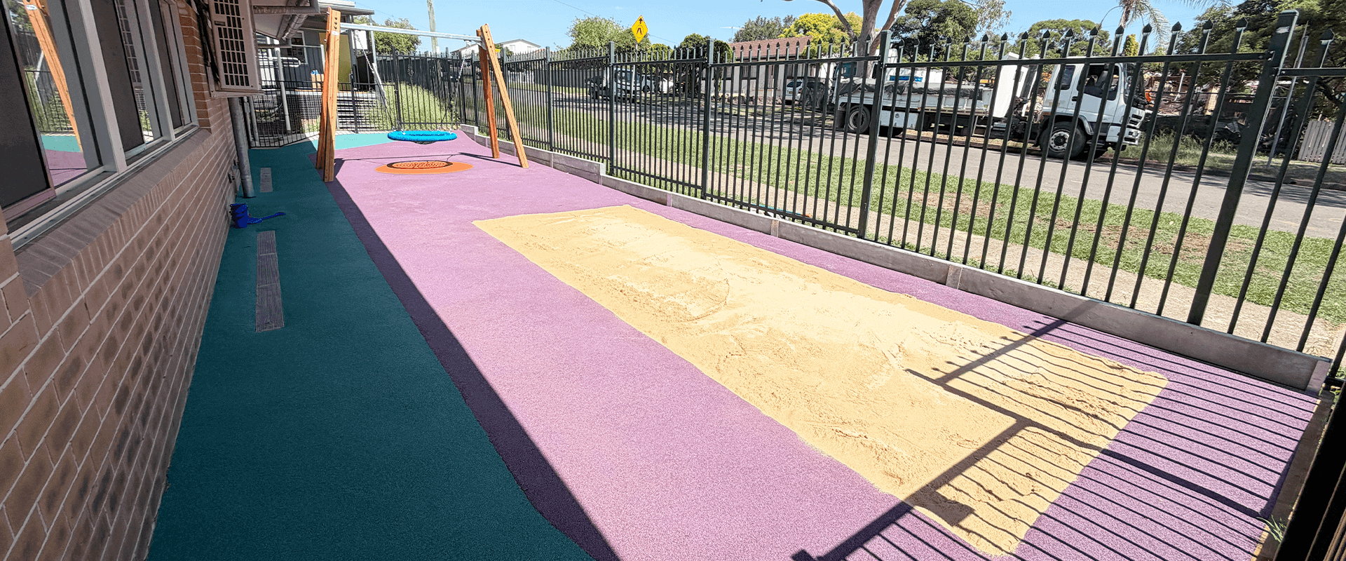 Playground with drainage system and colorful landscape surface.
