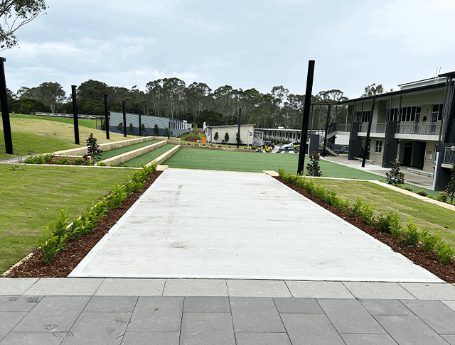 Contemporary residential landscape pathway with green lawns and new plantings.